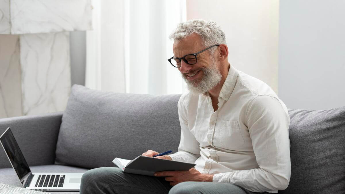 homem sênior estudando no laptop enquanto aprende pela internet