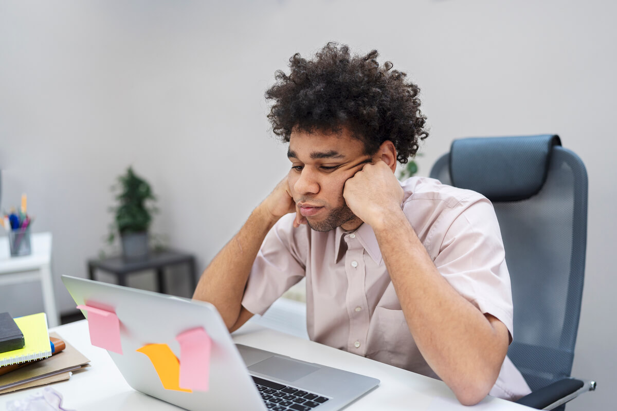 Jovem cansado com TDAH tentando estudar usando o computador.