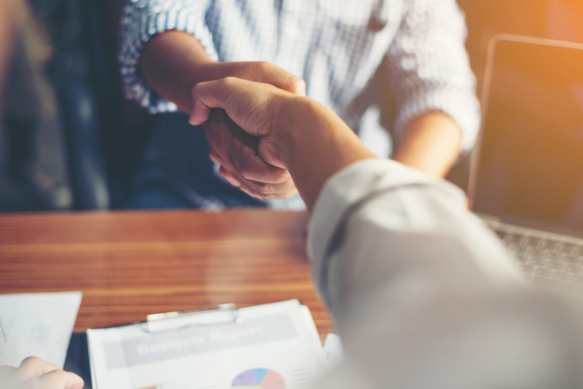 Executivos garantindo empregabilidade com um aperto de mãos.