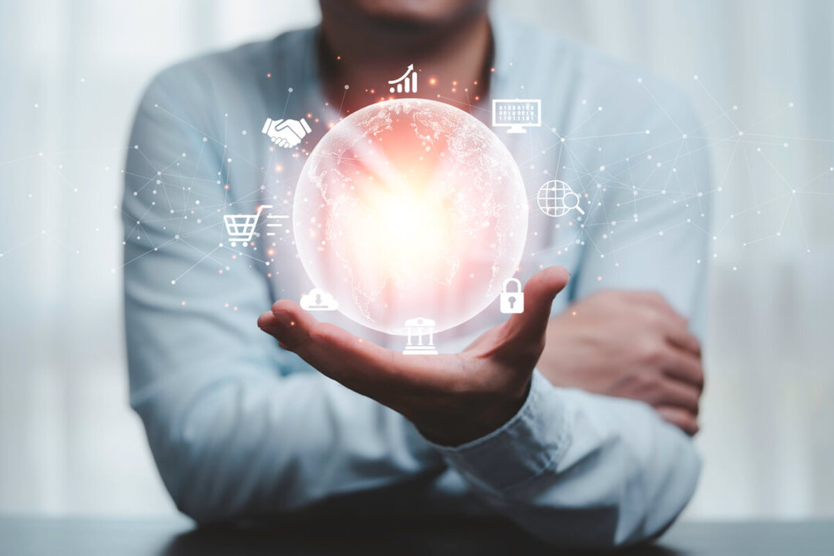 IoT: homem de camisa segurando uma bola em holograma com vários ícones, representando a tecnologia.